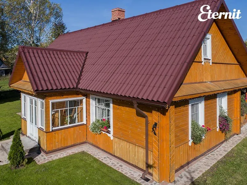 Koka māja ar ķiršu sarkanu Eternit Gotika jumtu
